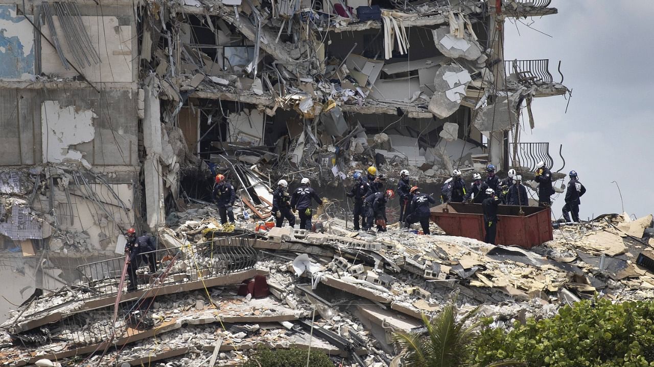 Members of the South Florida Urban Search and Rescue team look for possible survivors in the partially collapsed 12-story Champlain Towers South condo building in Surfside, Florida. Credit: AFP Photo