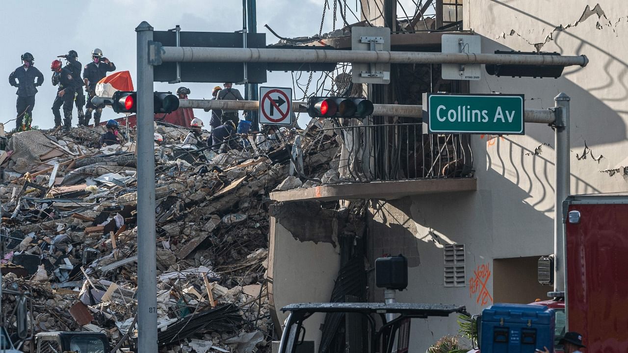 Members of the South Florida Urban Search and Rescue team look for possible survivors in the partially collapsed 12-story Champlain Towers South condo building on June 27, 2021 in Surfside, Florida. Credit: AFP Photo