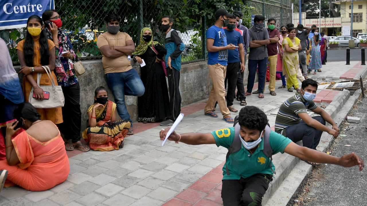 Several people wait outside a vaccination Center in Malleswaram to get Covid-19 vaccine in Bengaluru. Credit: DH Photo/Pushkar V