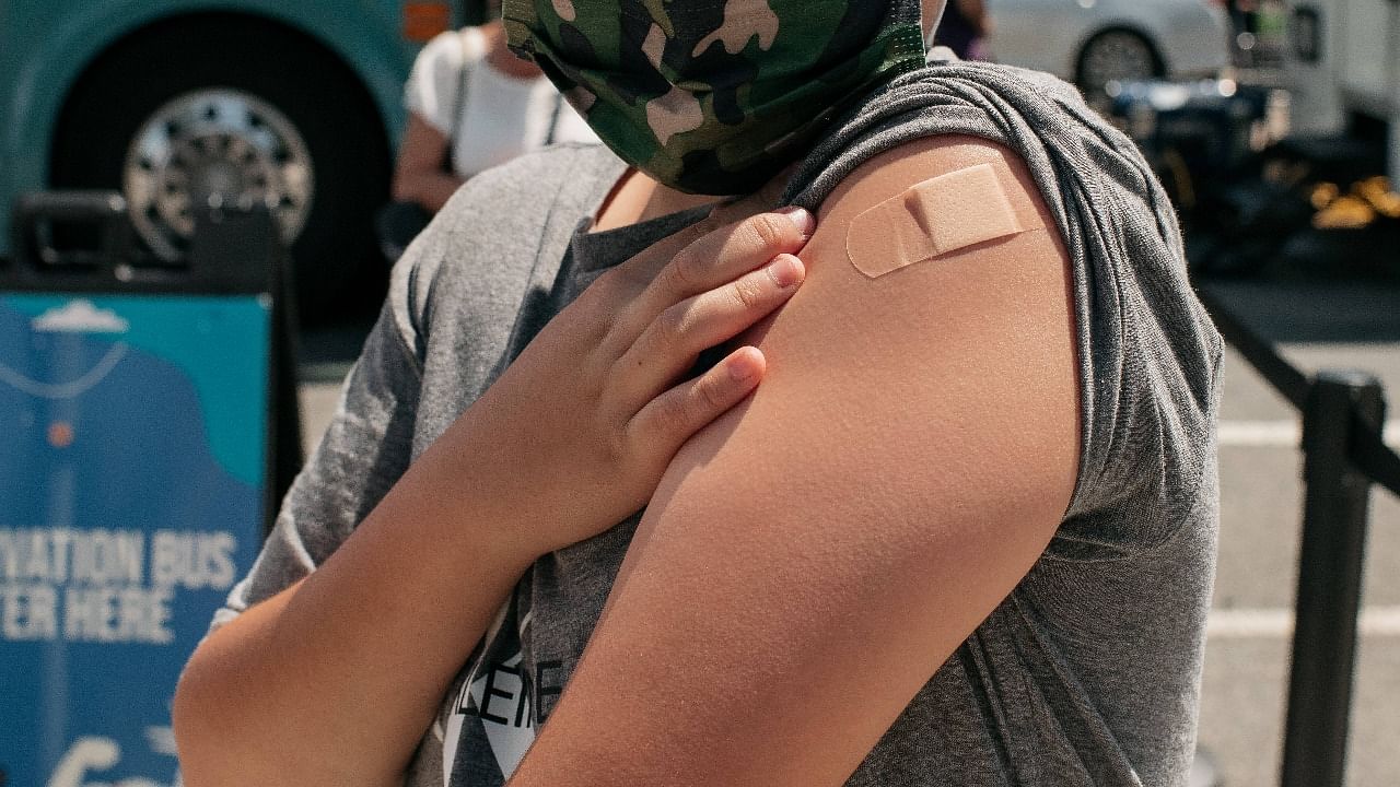 A 13-year-old newly vaccinateda against Covid-19 shows his bandage at a pop-up vaccination site in the Jackson Heights neighbourhood in the Queens borough in New York City. Credit: AFP Photo