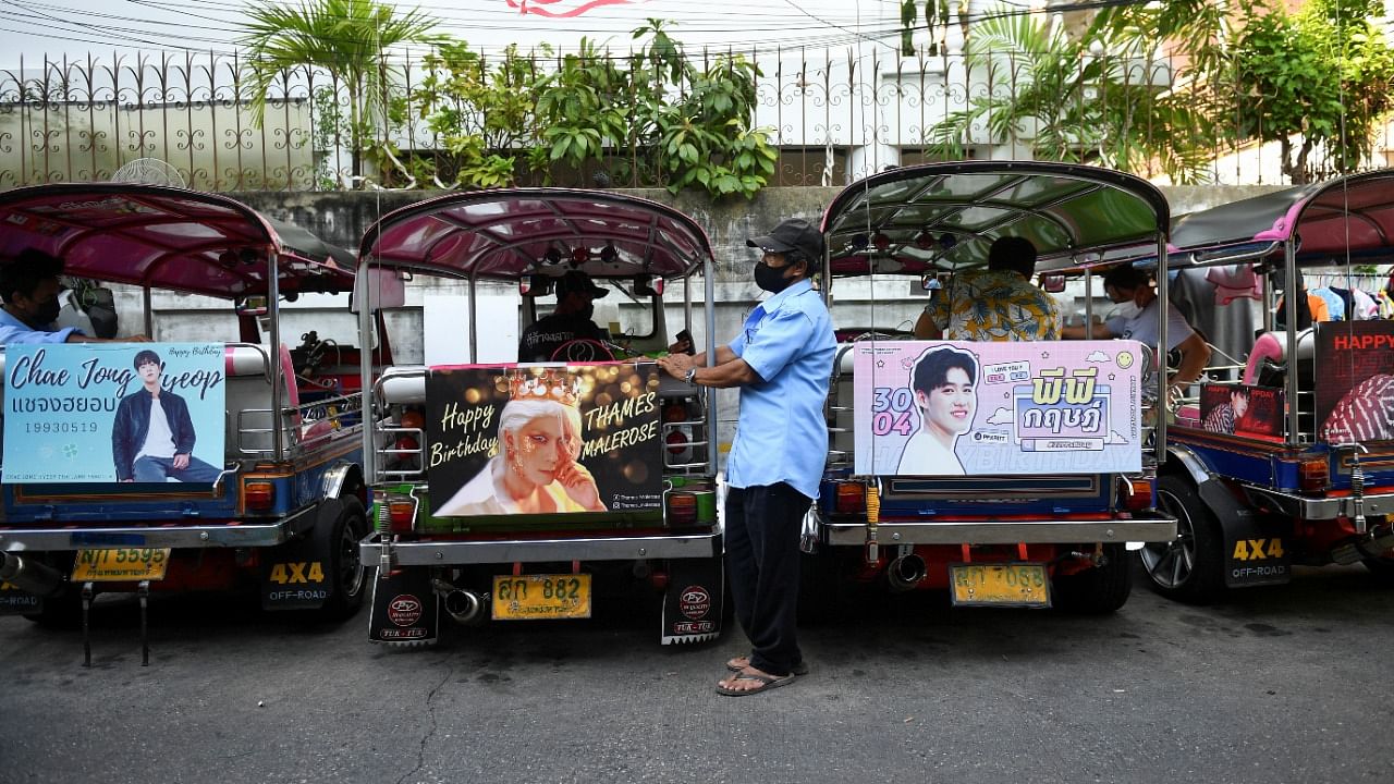 Tuk-tuk drivers, with their vehicles decorated with banners of Thai and Korean stars, wait for customers in Bangkok. Credit: Reuters Photo