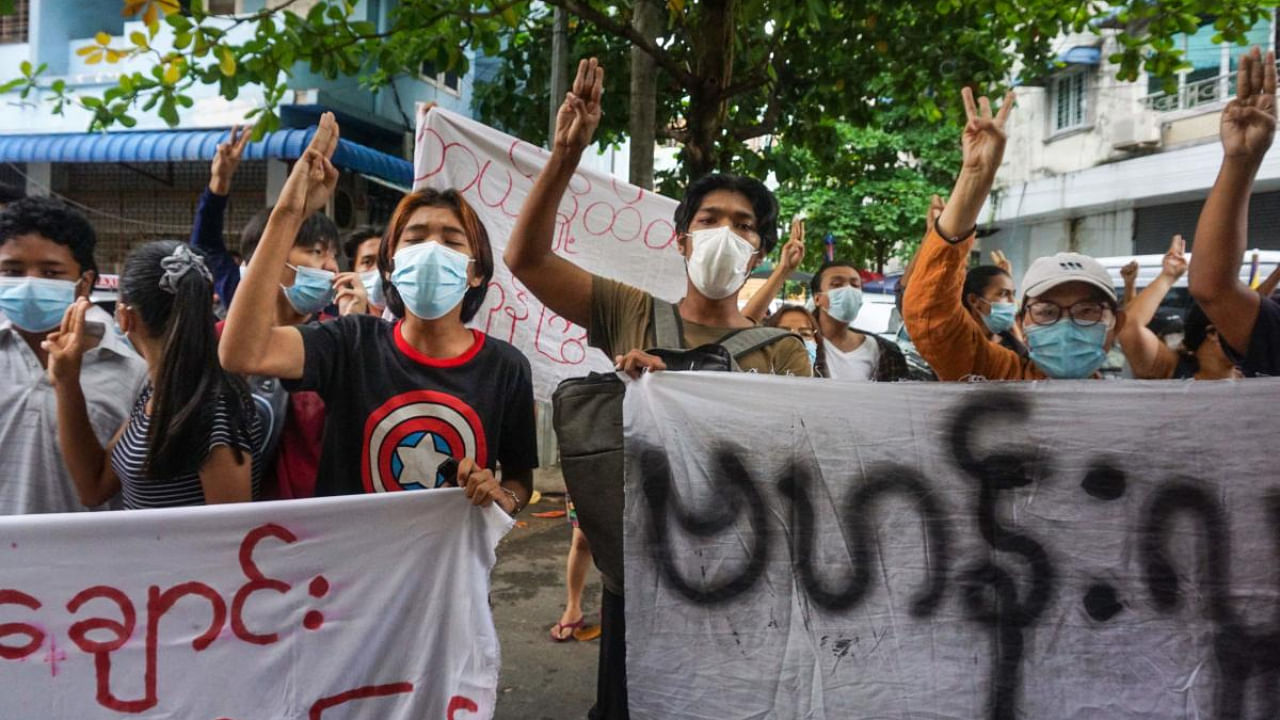 Protesters make the three-finger salute during a flash mob demonstration against the military coup in Yangon. Credit: AFP Photo