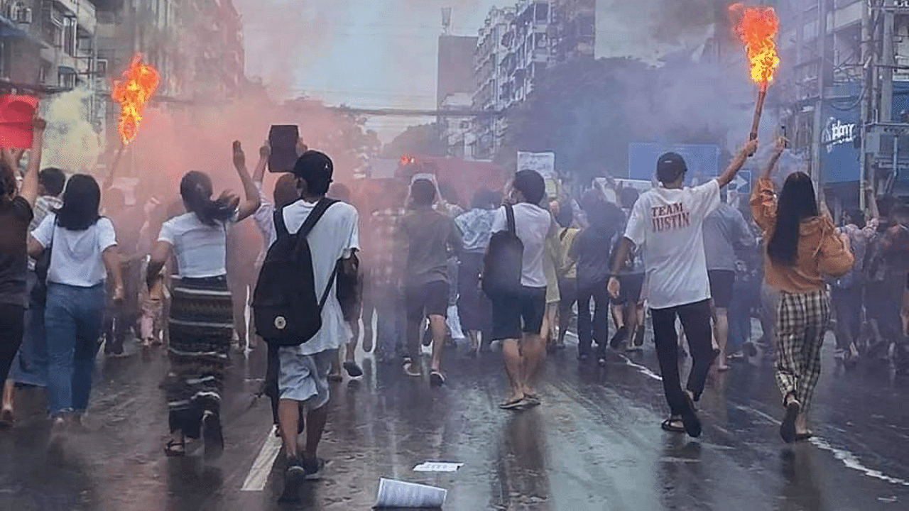 Protesters march with flaming torches as they take part in a demonstration against the military coup in Yangon. Credit: AFP Photo