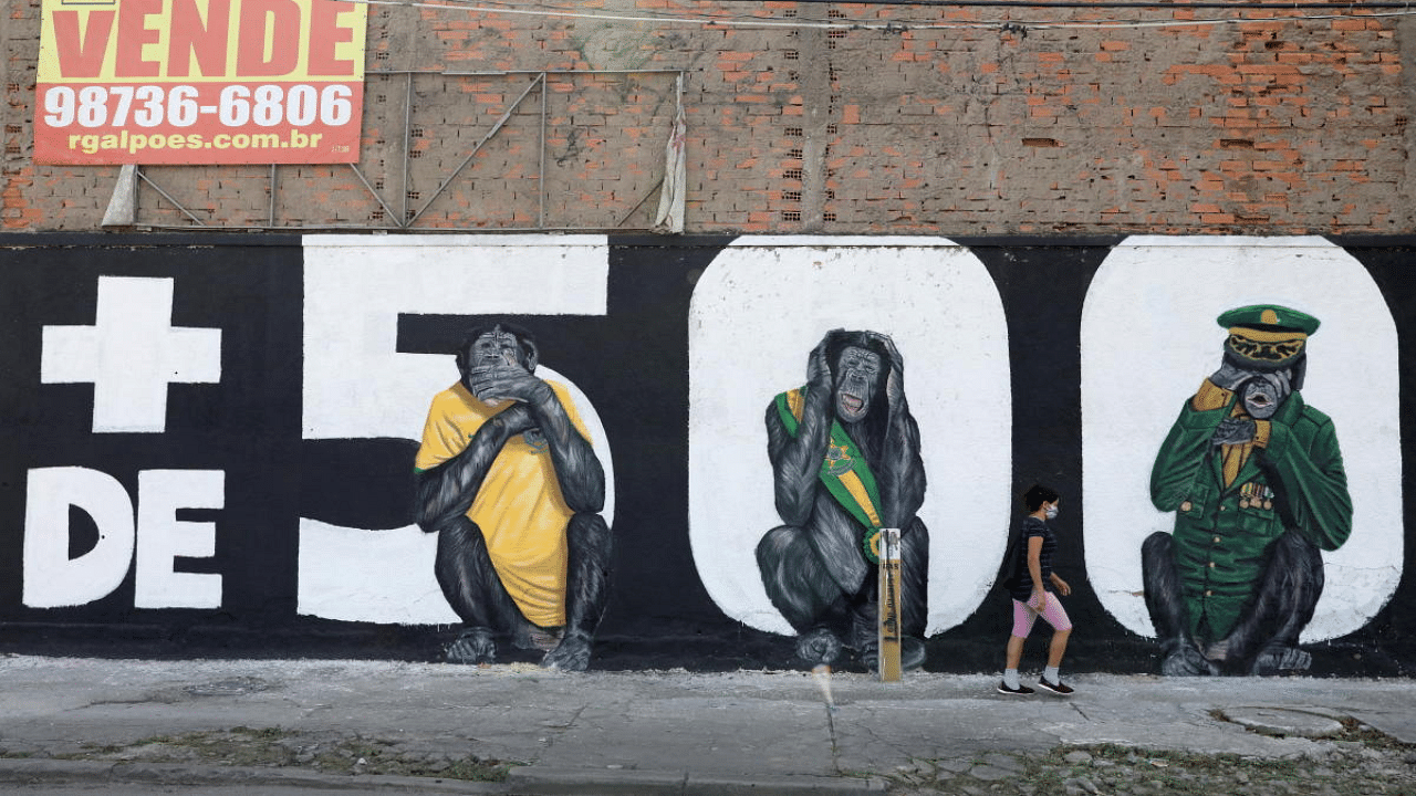 A person walks past graffiti which reads "More than 500 thousand dead", amid the coronavirus pandemic, in Rio de Janeiro, Brazil. Credit: Reuters Photo