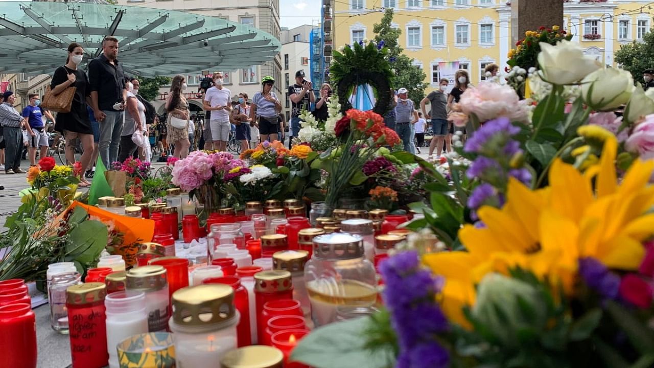People mourn next to flowers and candles in front of a department store in Wuerzburg, Germany, June 27, 2021, after a knife attack on Friday by a 24-year-old Somali immigrant, killing three women and seriously injuring five other women. Credit: Reuters Photo