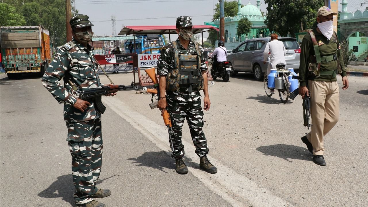 Security personnel stand guard at Jammu-Pathankot National Highway after troops spotted drones separately flying over Kunjwani and Kaluchak at midnight. Credit: PTI Photo