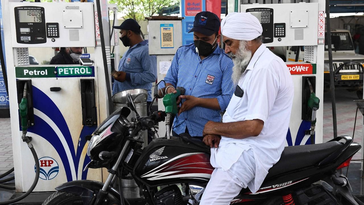 A fuel pump attendant fills a motorbike petrol tank at a gas station. Credit: AFP Photo