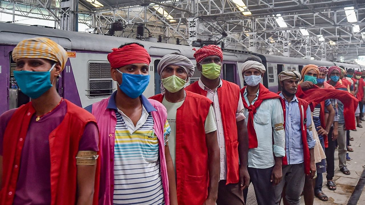 Porters wait in a long queue to collect relief material at the Sealdah Station during the Covid-induced lockdown in Kolkata, Wednesday, June 30, 2021. Credit: PTI Photo