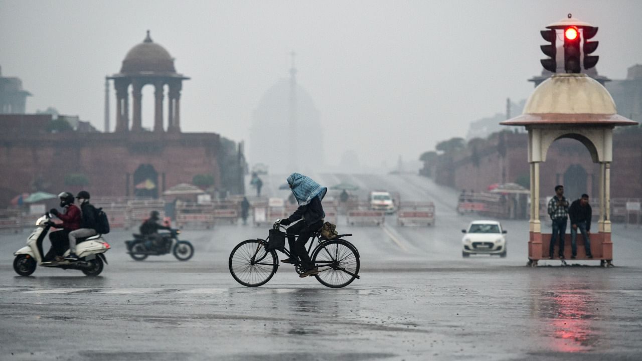 Commuters travel during light rains in Delhi. Credit: PTI Photo