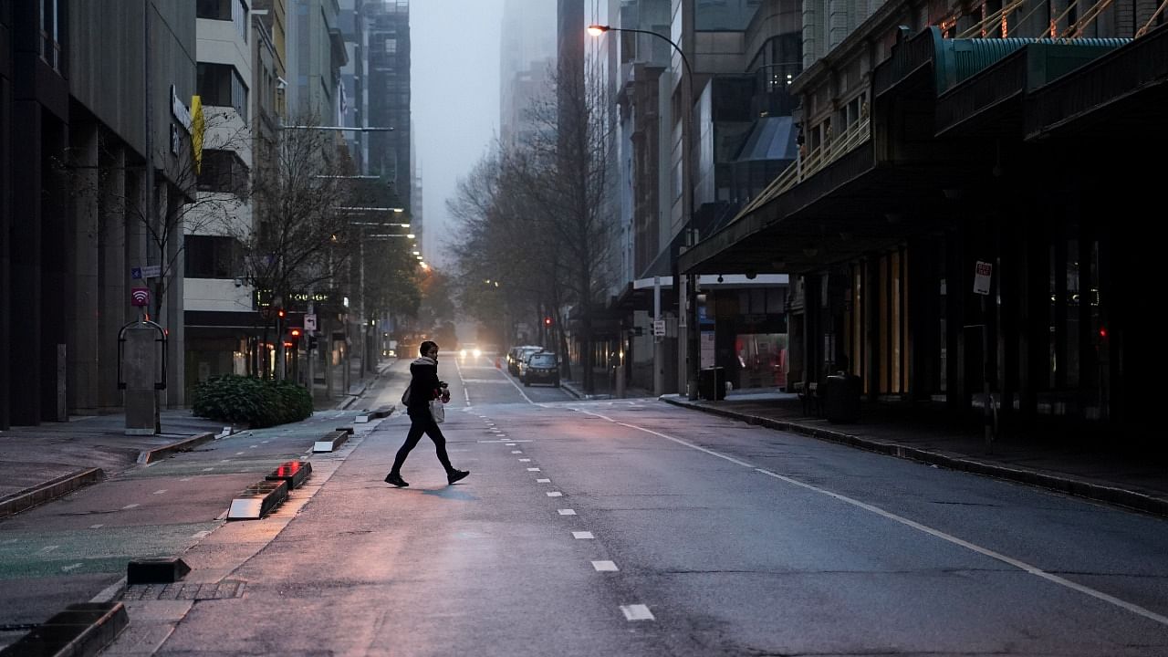A pedestrian crosses an empty street in the deserted city centre at morning commute hour during a lockdown to curb the spread of a Covid-19 outbreak in Sydney. Credit: Reuters Photo