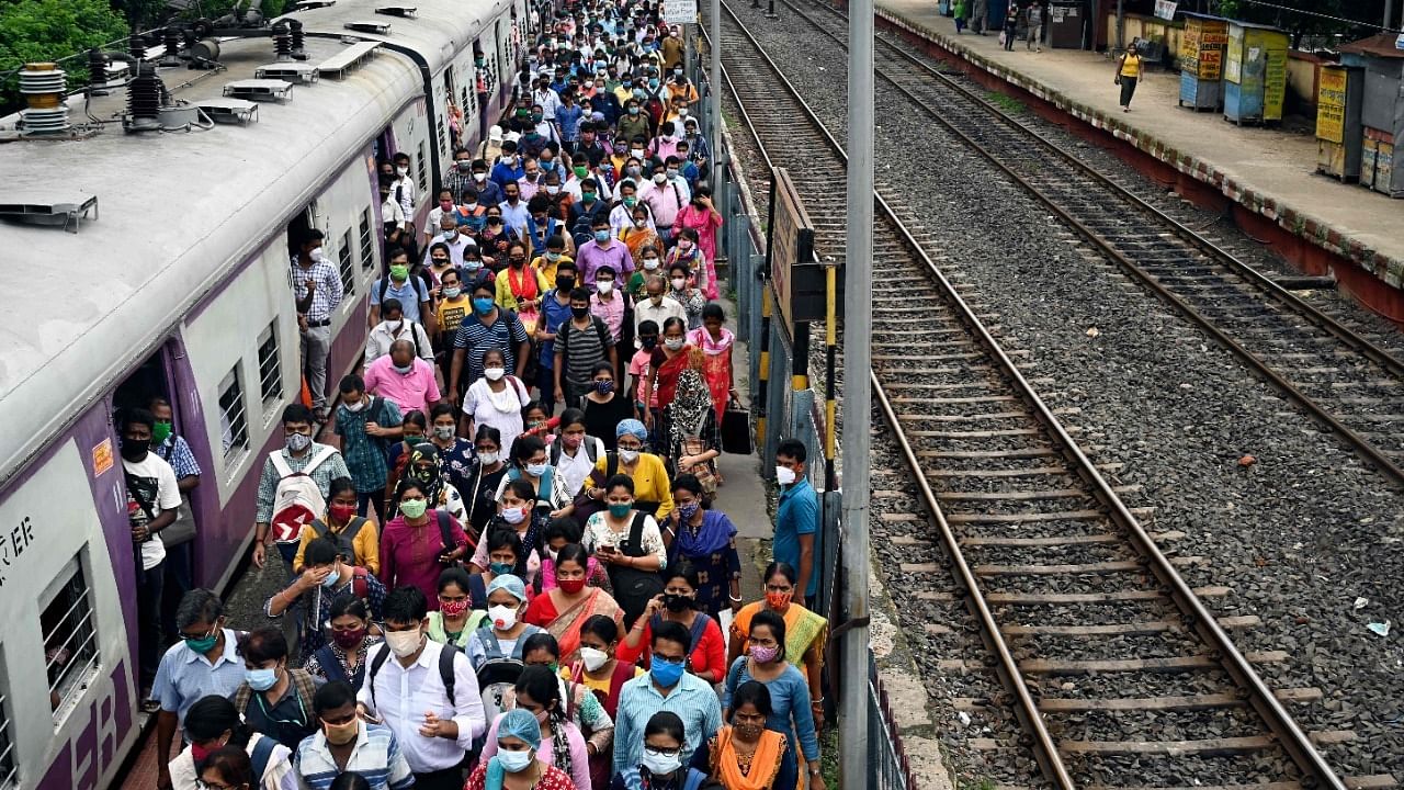 Commuters walk along a platform after arriving in a special service local train in West Bengal. Credit: AFP Photo