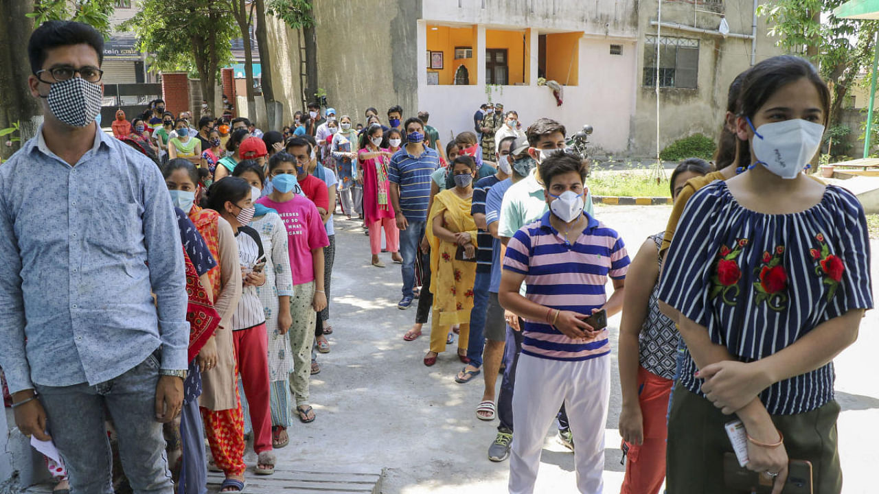 Beneficiaries wait in a queue to receive a dose of Covid-19 vaccine at a vaccination centre in Jammu. Credit: PTI Photo