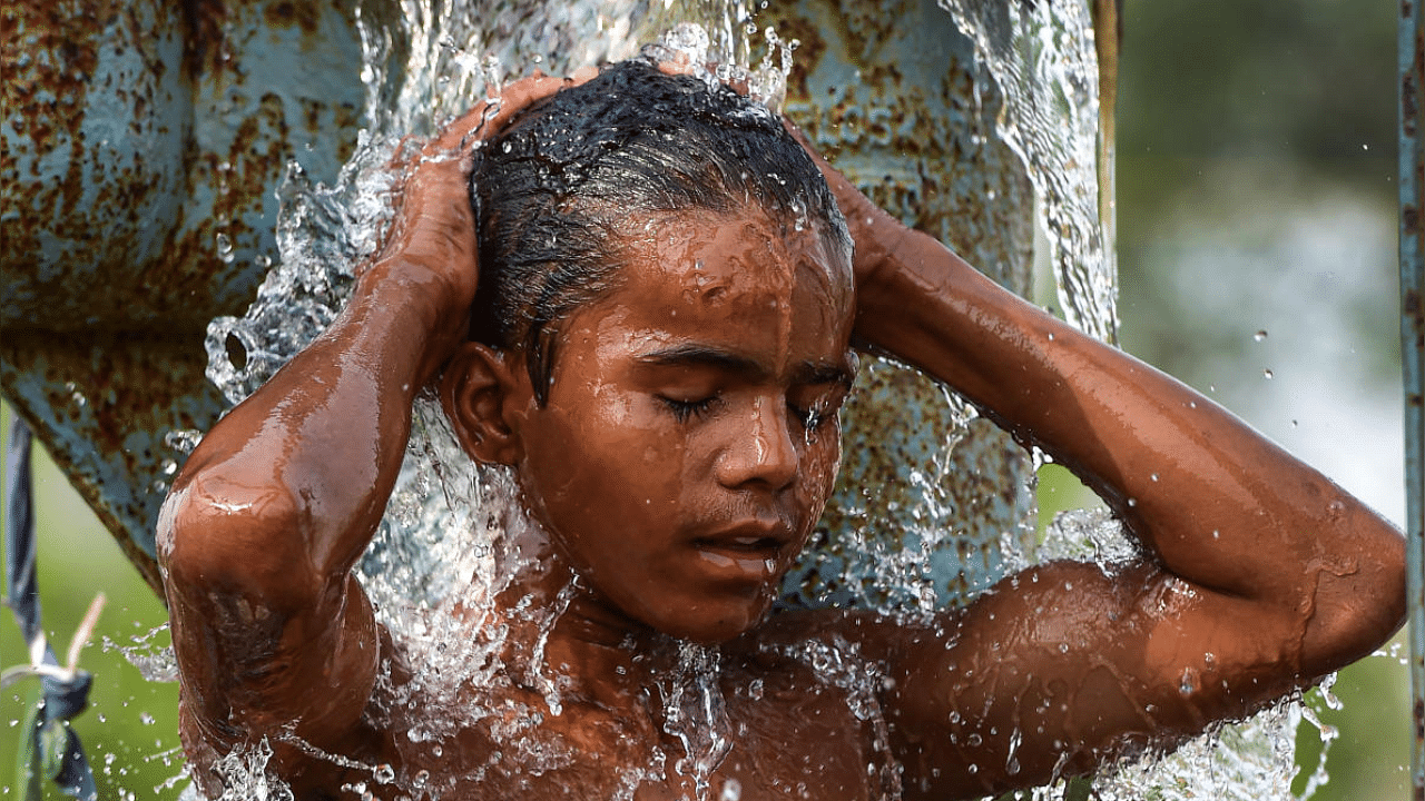 <div class="paragraphs"><p>A child takes a bath under a leaking pipe to get respite from the scorching heat, in New Delhi. Image for representation only.</p></div>