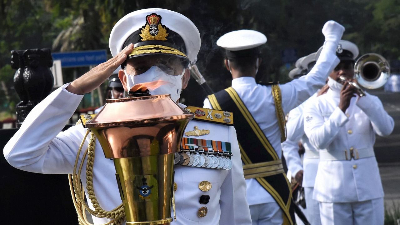 Flag Officer Commanding-in-Chief, Southern Naval Command, Vice Admiral A. K Chawla salutes the Victory Flame which was lit by the Prime Minister during the 50th anniversary of the victory in the 1971 Indo-Pak war, in Kochi. Credit: PTI Photo
