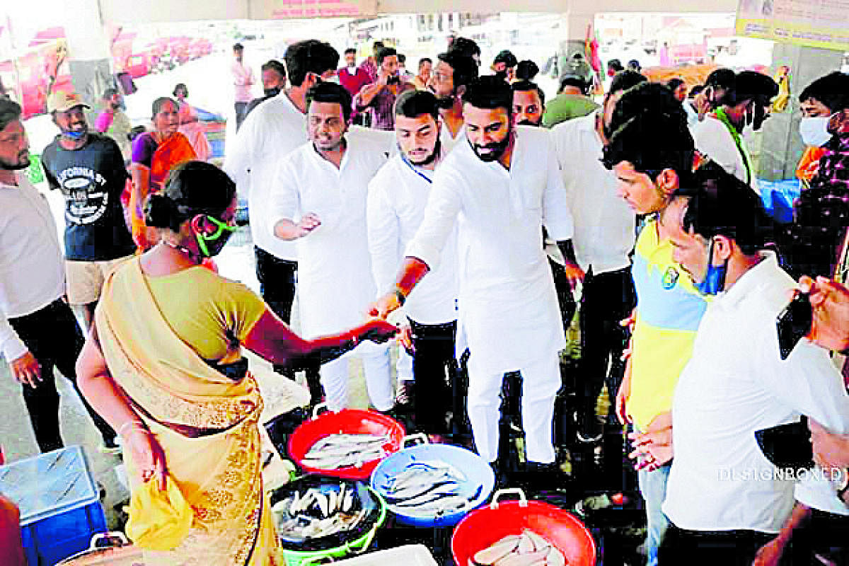 State Youth Congress designate president Mohammed Nalapad purchases fish from a fisherwoman at Malpe harbour.