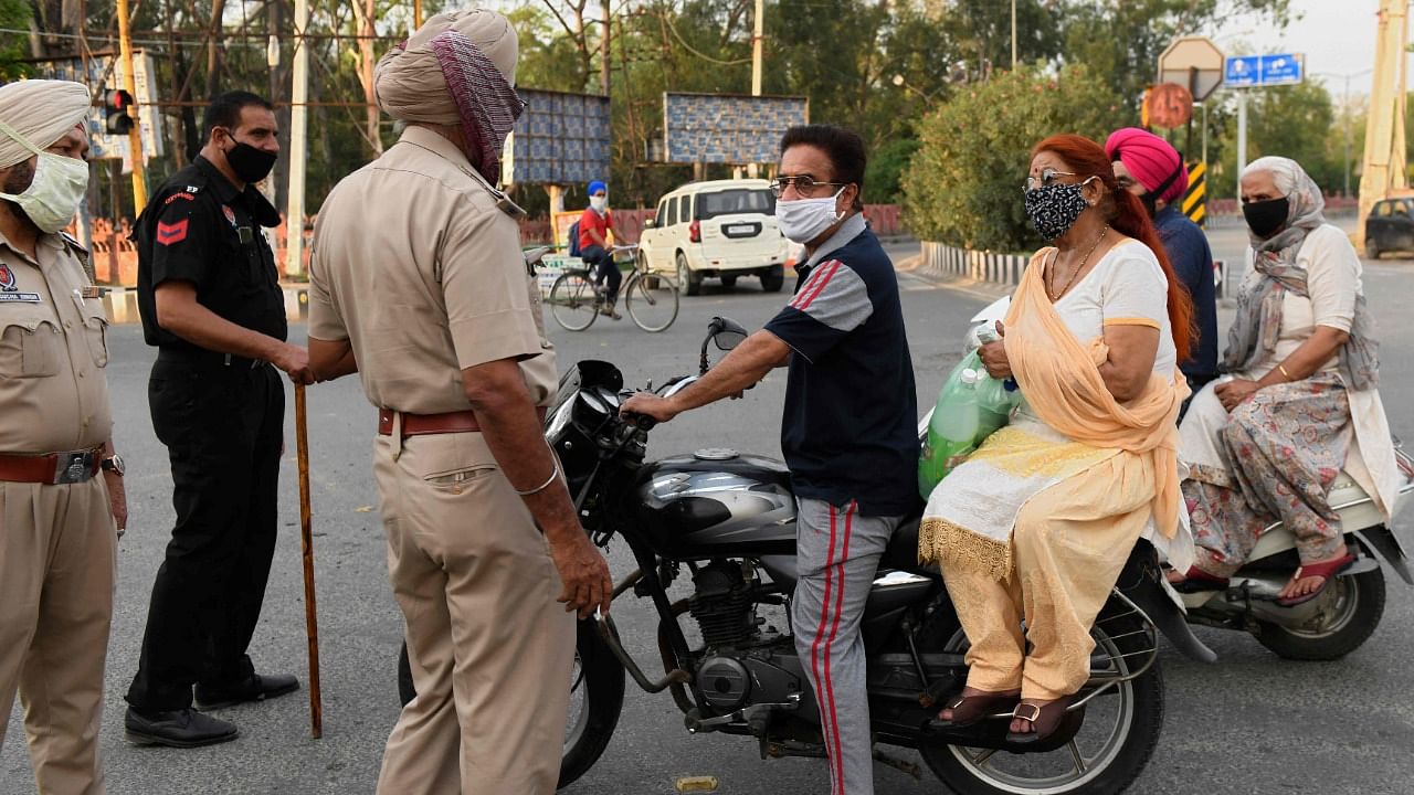 Police personnel check the movement of commuters on a street during a state imposed lockdown to curb the spread of Covid-19 coronavirus in Amritsar on May 16, 2021. Credit: AFP Photo