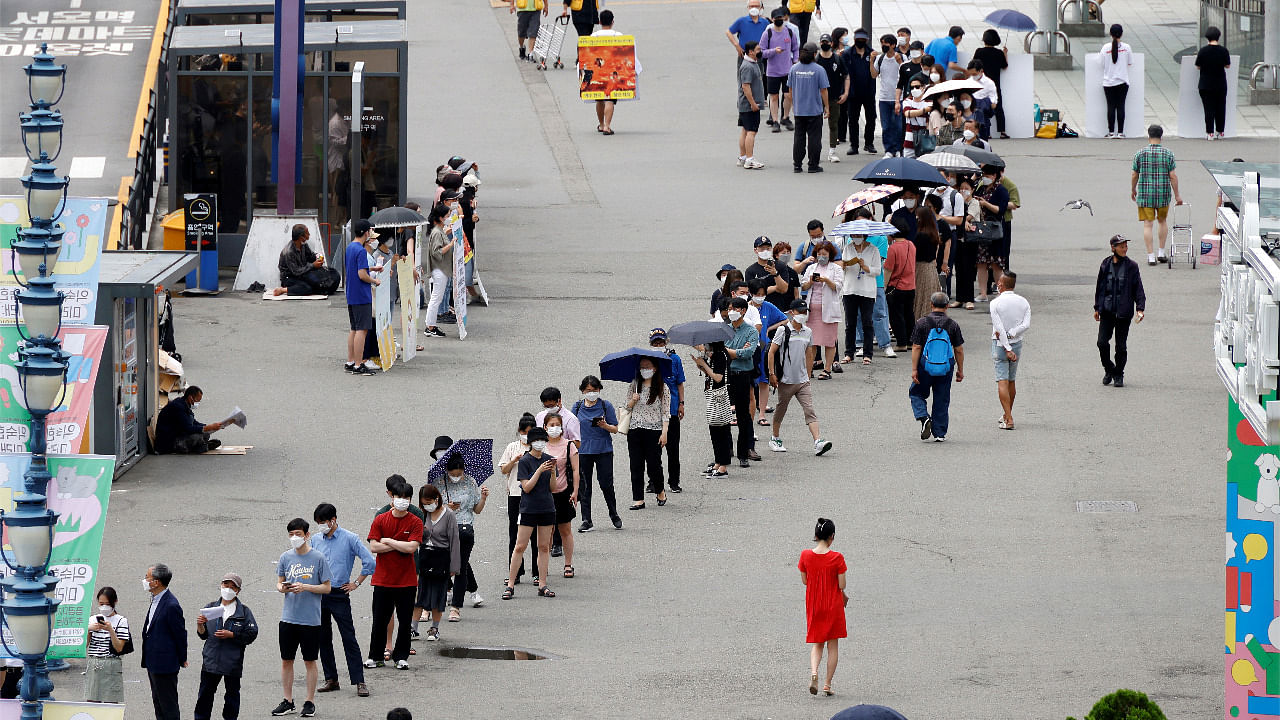 People wait in line for a Covid-19 test at a testing site which is temporarily set up at a railway station in Seoul, South Korea. Credit: Reuters Photo