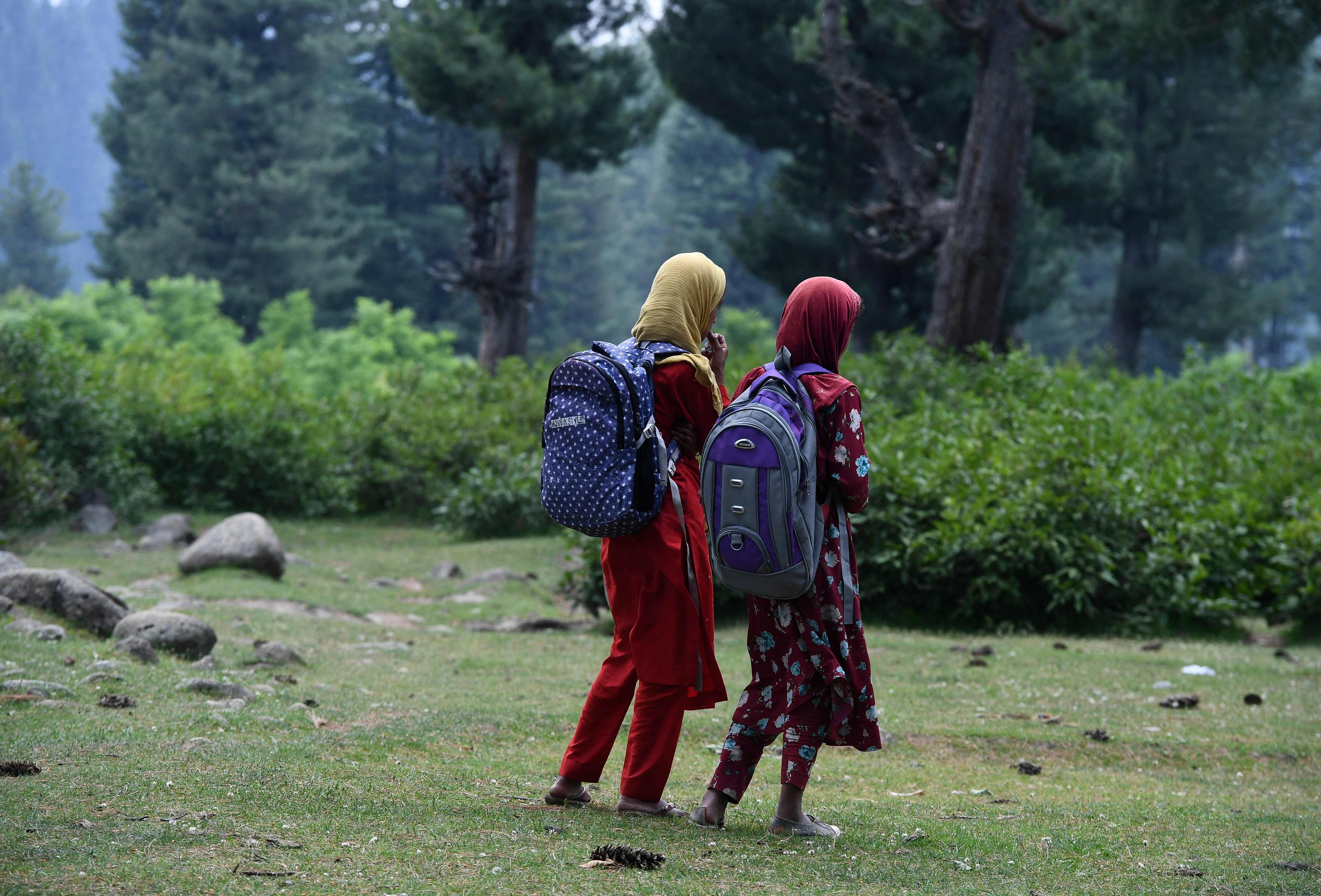 School children walk back home after attending an open-air school situated on top of a mountain in J&K. Credit: AFP Photo
