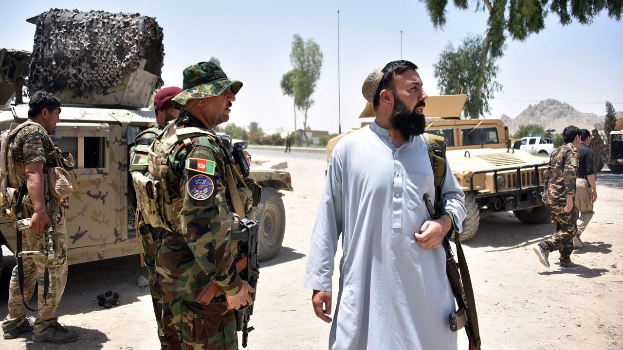 Afghan security personnel stand guard along the road amid ongoing fight between Afghan security forces and Taliban fighters in Kandahar on July 9, 2021. Credit: AFP Photo