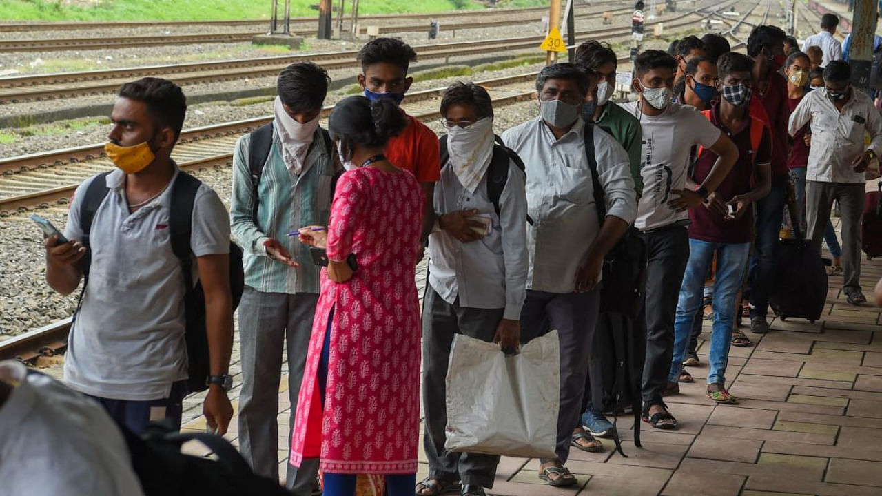 Passengers queue up to test for the Covid-19 after arriving at a railway platform in Mumbai. Credit: AFP Photo