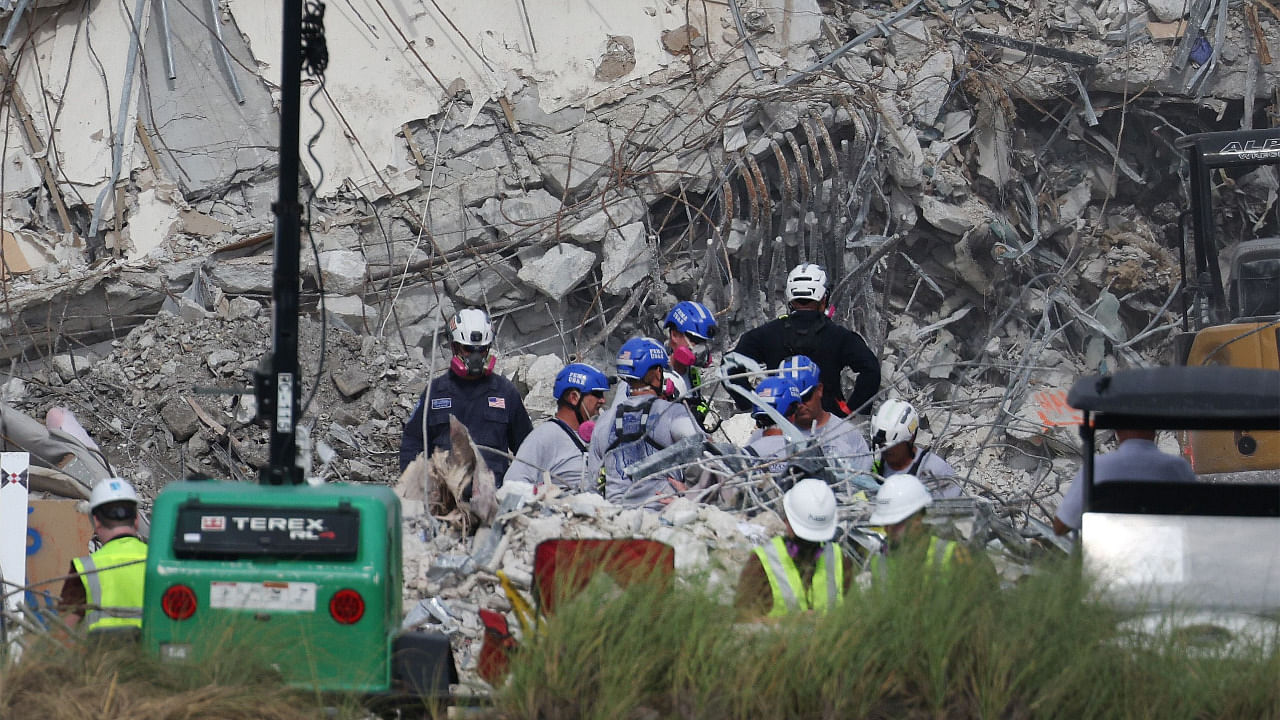 Rescue workers work to dig through the rubble of the collapsed 12-story Champlain Towers South condo building. Credit: AFP Photo