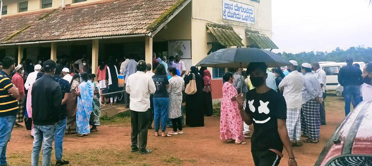 People wait for their turn to get vaccinated at Karnataka Public School in Napoklu.