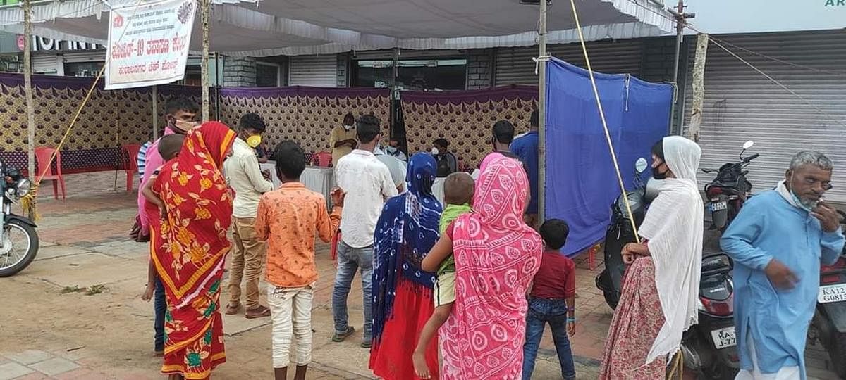 Migrant labourers undergo swab tests at a check post in Kushalnagar.