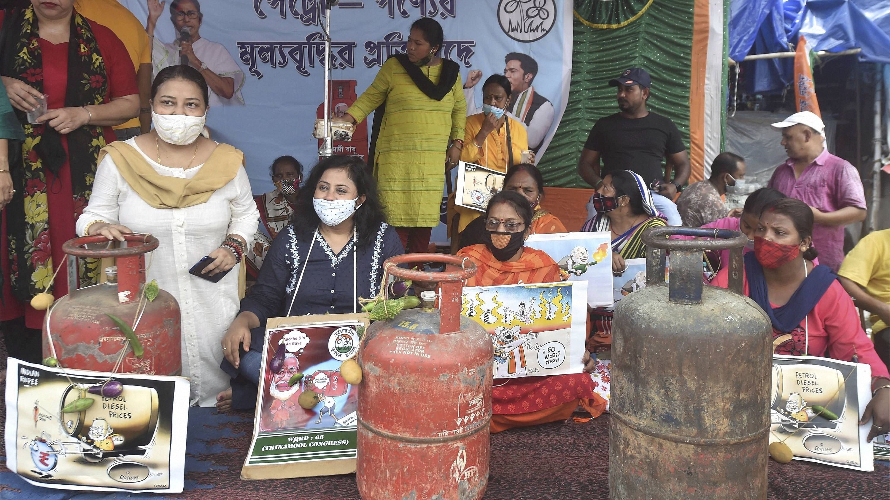 TMC activists with posters and cylinders protest against fuel and LPG prices in Kolkata. Credit: PTI Photo