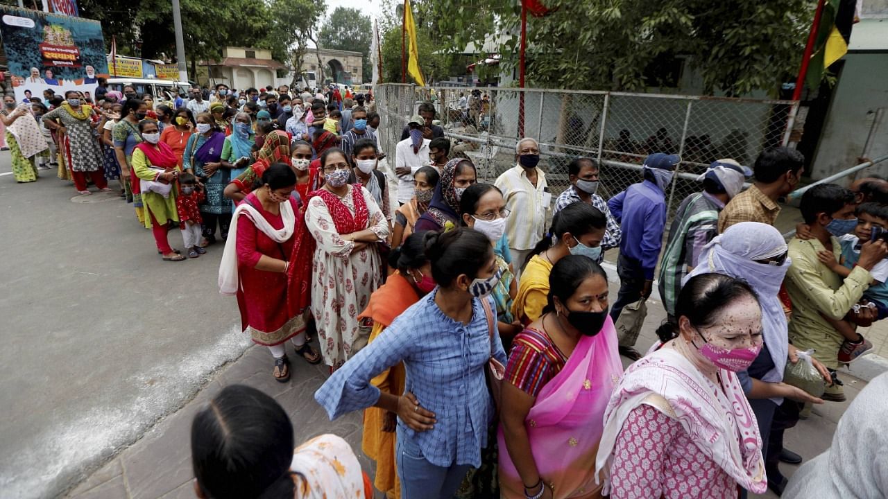 Hindu devotees stand in queues waiting to offer prayers at Lord Jagannath Temple ahead of 144th Annual Rath Yatra in Ahmedabad, Saturday, July 10, 2021. Credit: PTI Photo