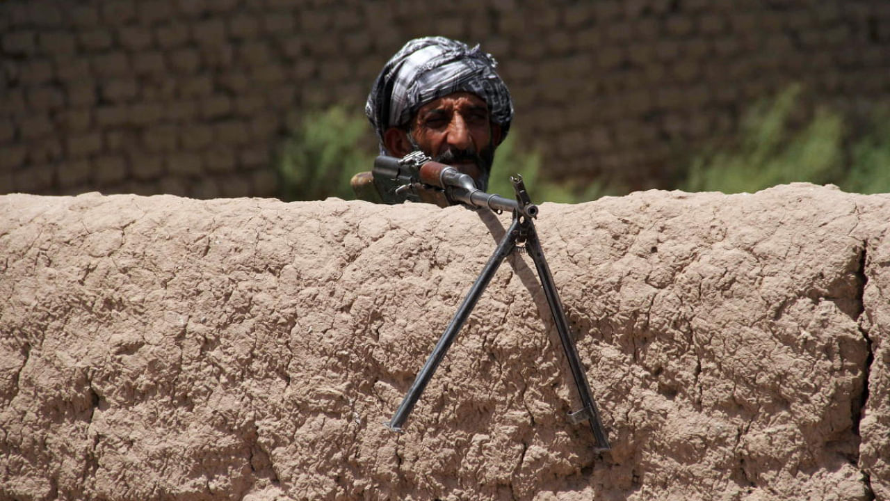 A former Mujahideen keeps watch at a check post as he holds a weapon to support Afghan forces in their fight against Taliban, on the outskirts of Herat province, Afghanistan. Credit: Reuters Photo