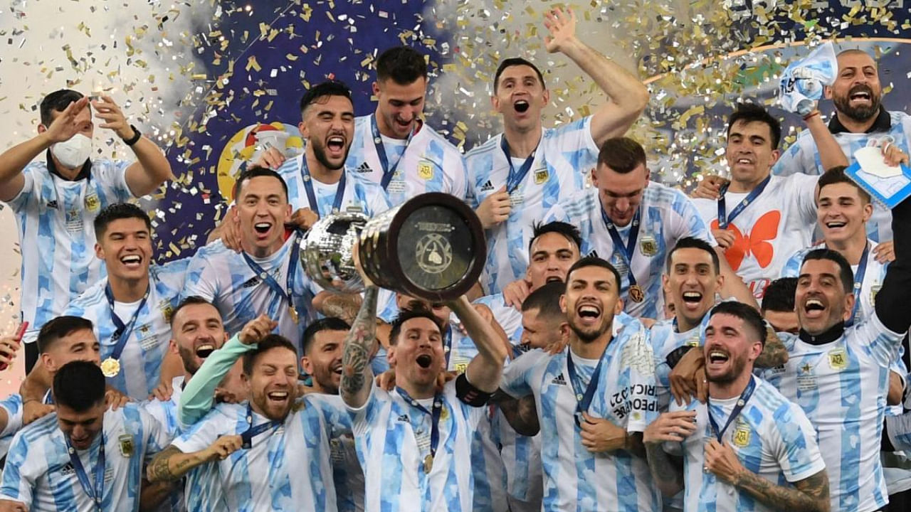 Argentina's Lionel Messi holds the trophy as he celebrates on the podium with teammates after winning the Conmebol 2021 Copa America football tournament final match against Brazil at Maracana Stadium in Rio de Janeiro, Brazil. Credit: AFP Photo