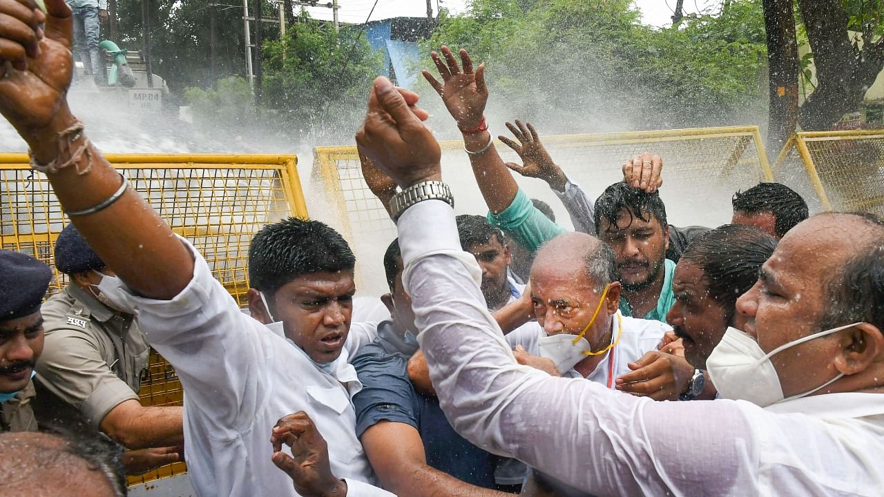 Digvijaya Singh (C) with Congress workers, being hit by police water cannon. Credit: PTI Photo