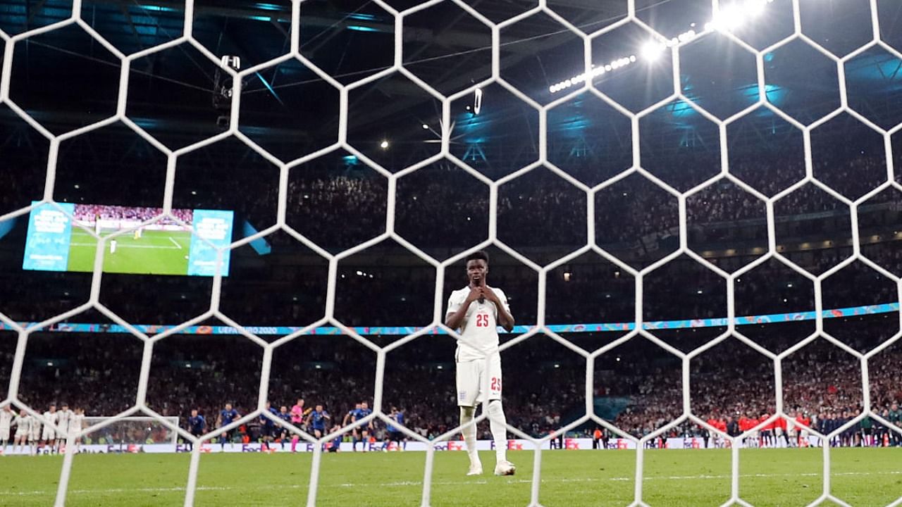 England's Bukayo Saka looks dejected after missing a penalty resulting in Italy winning the penalty shootout and Euro 2020. Credit: Reuters Photo