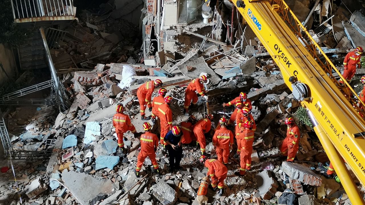 Rescue workers work next to a crane at the site where a hotel building collapsed in Suzhou. Credit: Reuters Photo