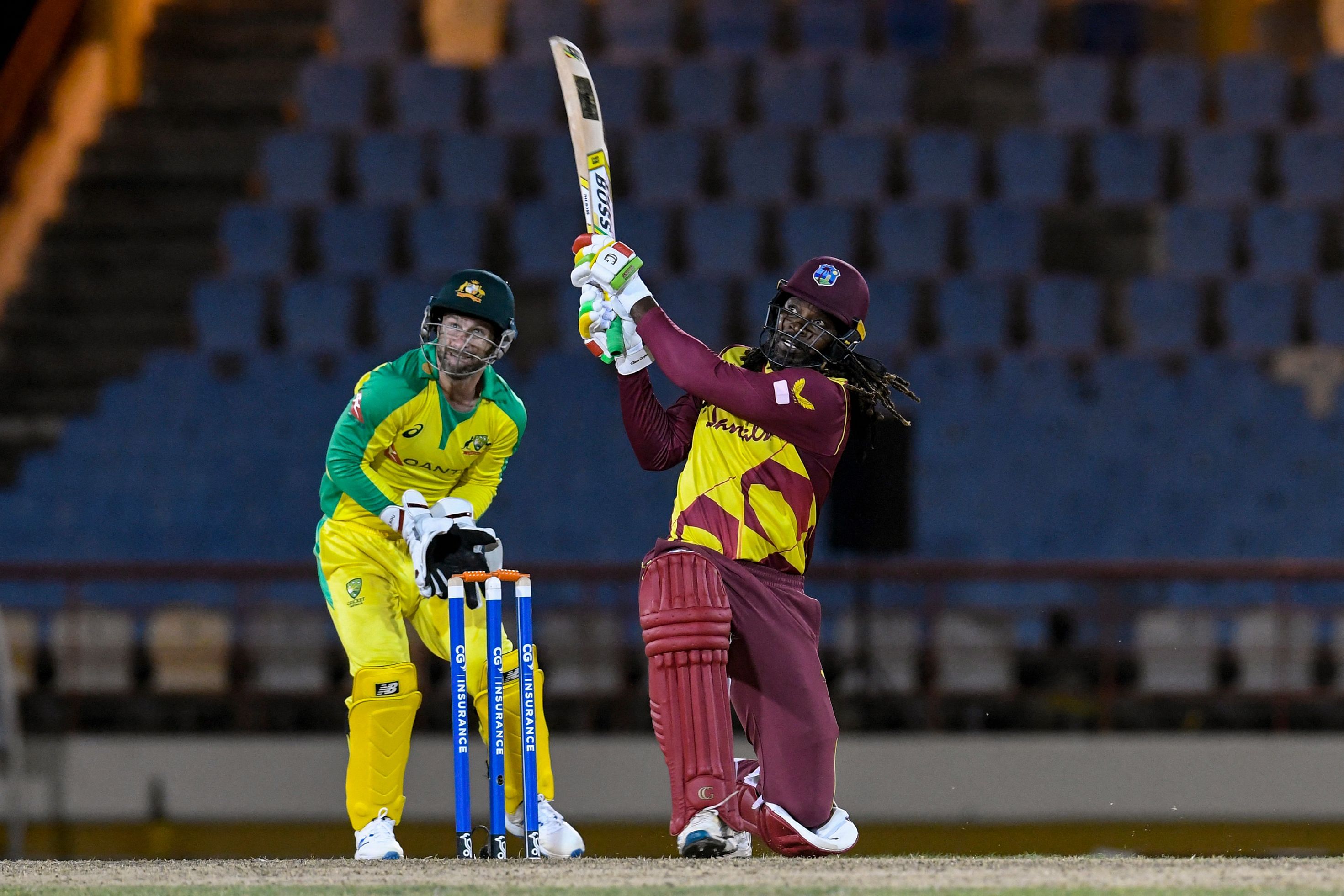 Chris Gayle (R) of West Indies hits 6 as Matthew Wade (L) of Australia watches during the 3rd T20I between Australia and West Indies at Darren Sammy Cricket Ground, Gros Islet, Saint Lucia, on July 12, 2021. Credit: AFP Photo