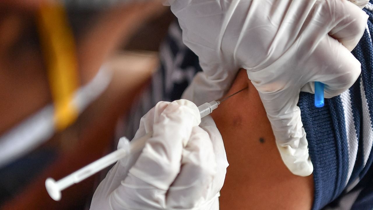 A medical staff inoculates a man with a dose of the Covishield AstraZeneca-Oxford's Covid-19 coronavirus vaccine at a drive-in vaccination facility in Mumbai. Credit: AFP Photo