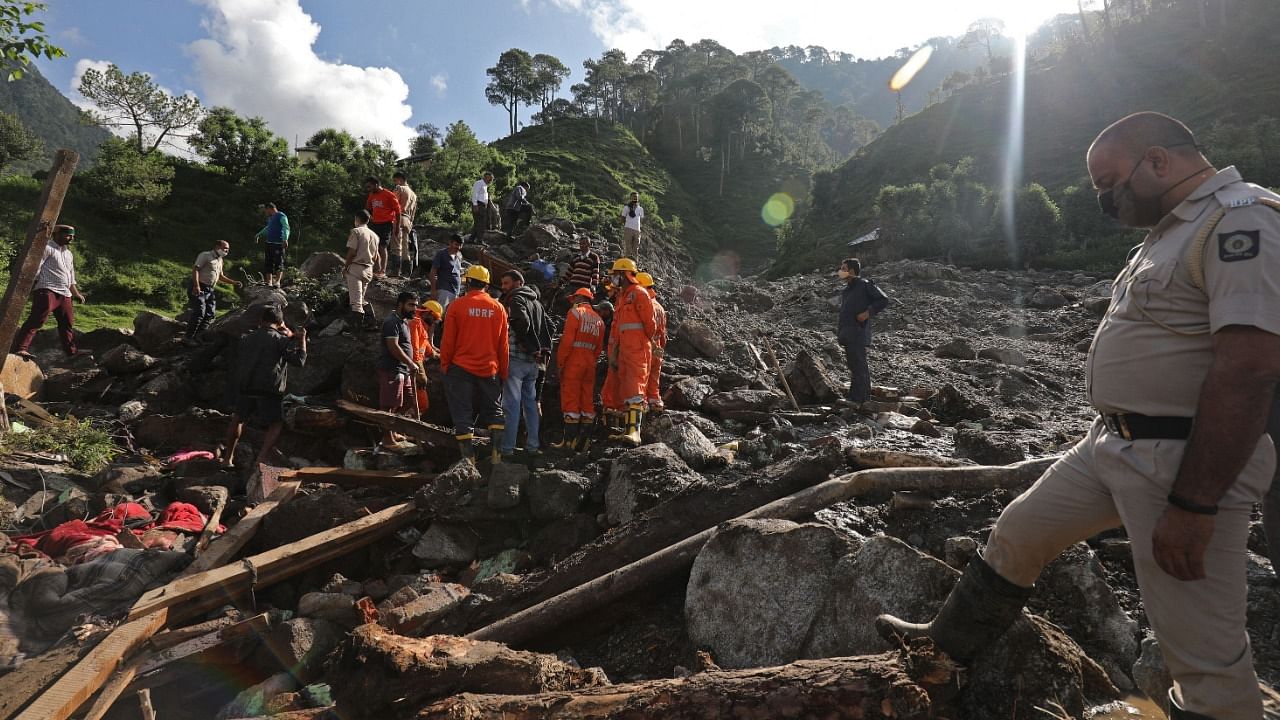 NDRF inspect the site of a landslide after heavy rains at Boh village in Kangra district. Credit: AFP Photo