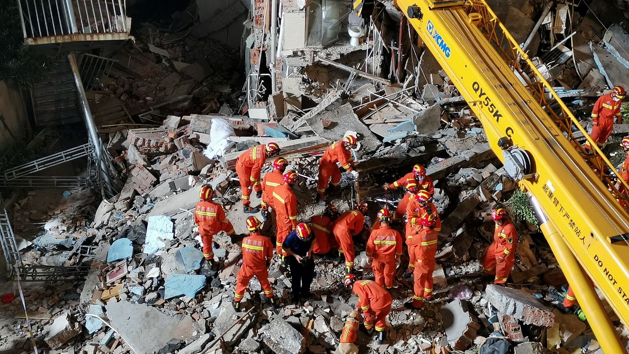 Rescue workers work next to a crane at the site where a hotel building collapsed in Suzhou. Credit: Reuters photo