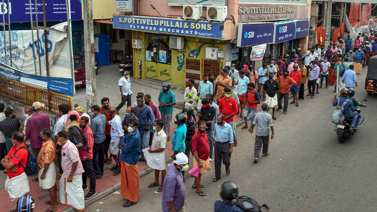 People wait in queues to buy liquor from a Beverages Corporation (Bevco) outlet in Thiruvananthapuram. Credit: PTI File Photo