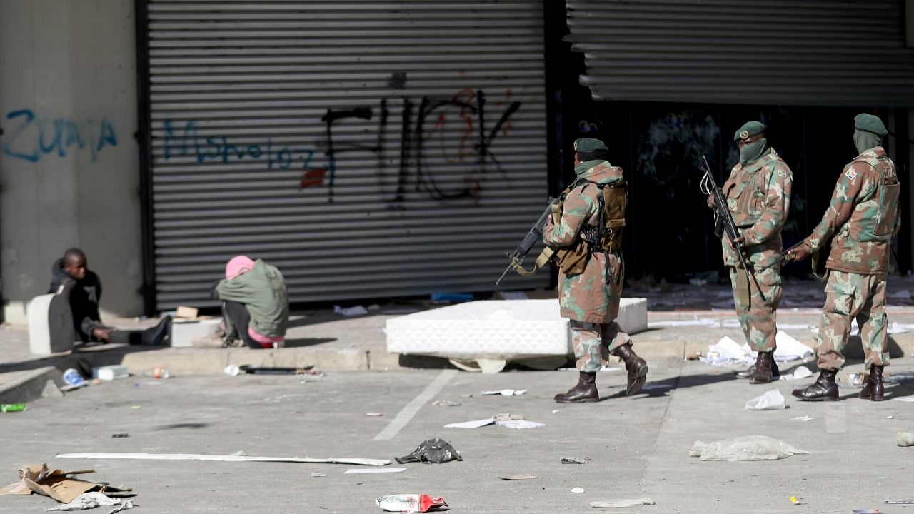 Members of the military keep guard next to suspected looters outside Diepkloof mall as the country deploys army to quell unrest linked to jailing of former President Jacob Zuma, in Soweto, South Africa. Credit: Reuters photo