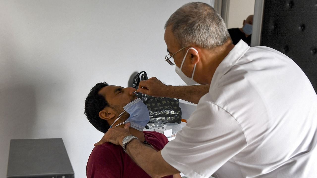 Tunisian physician Hichem Ouadi takes a swab sample from a patient to test for Covid-19 at a clinic in the town of Bou Mhel in Tunisia's Ben Arous province southeast of the capital on July 7, 2021. Credit: AFP Photo
