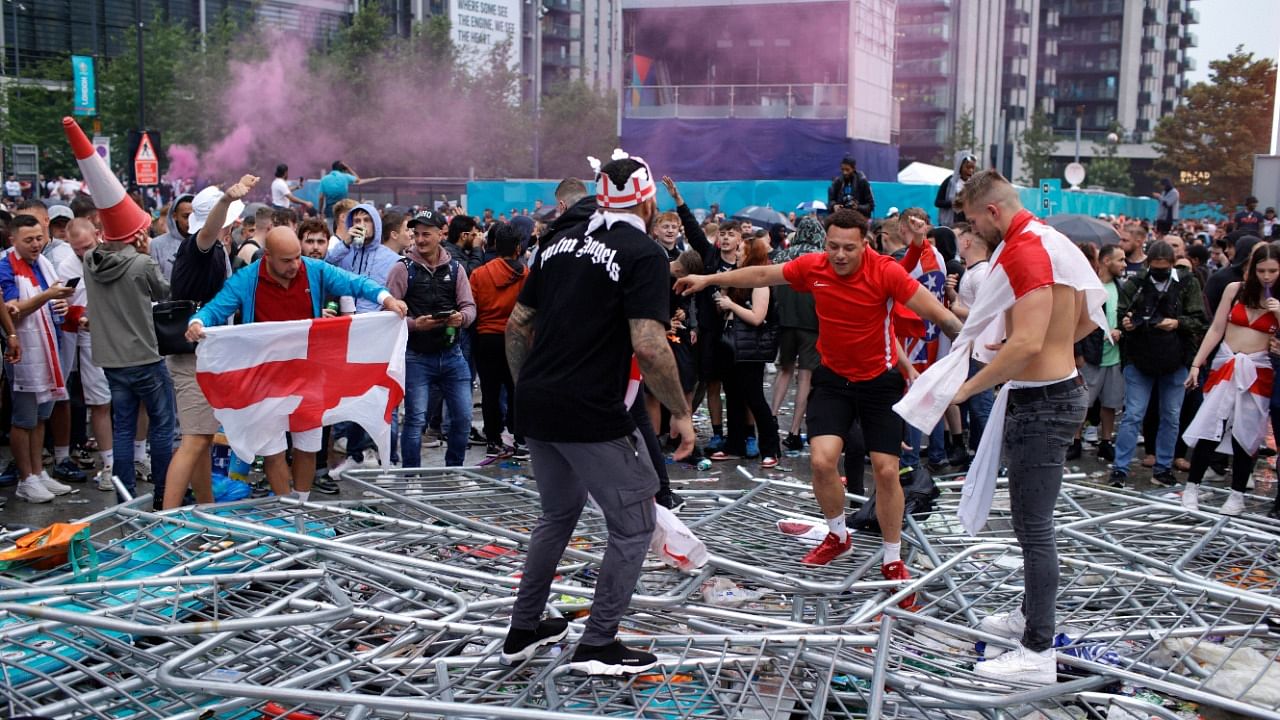 Supporters trample on barricades outside Wembley Stadium in London, during the Euro 2020 final. Credit: AP Photo