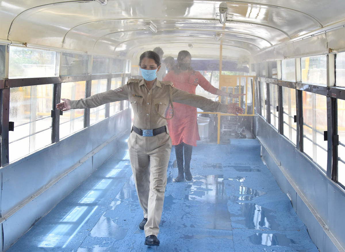 People pass through a mobile sanitiser bus, inaugurated by the KSRTC at Shantinagar on Saturday. DH Photo/Janardhan B K