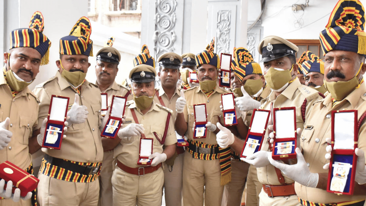Personnel of the Karnataka Fire and Emergency Services, Home Guards and Civil Defence pose with the medals presented to them, in Bengaluru on Tuesday. Credit: DH Photo