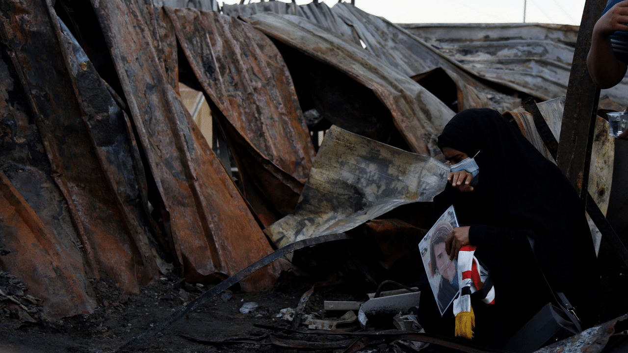 A woman sits amid debris at al-Hussain Covid hospital where a fire broke out, in Nassiriya. Credit: Reuters Photo