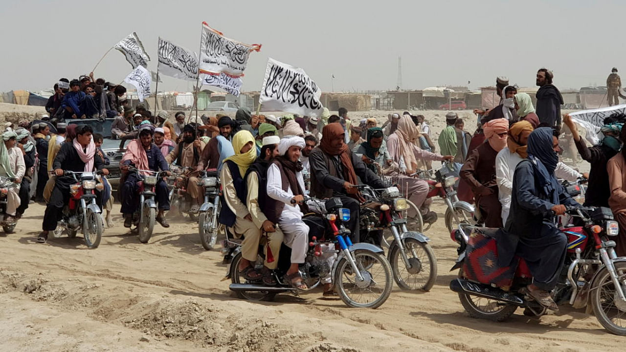 People on vehicles, holding Taliban flags, gather near the Friendship Gate crossing point in the Pakistan-Afghanistan border town of Chaman, Pakistan. Credit: Reuters Photo