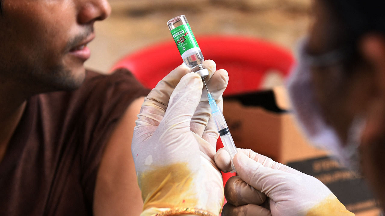 A health worker prepares to inculate a student with a dose of the Covishield vaccine. Credit: Reuters Photo