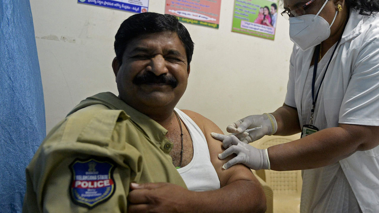 A medical staff inoculates a police personnel with a Covid-19 vaccine. Credit: AFP Photo