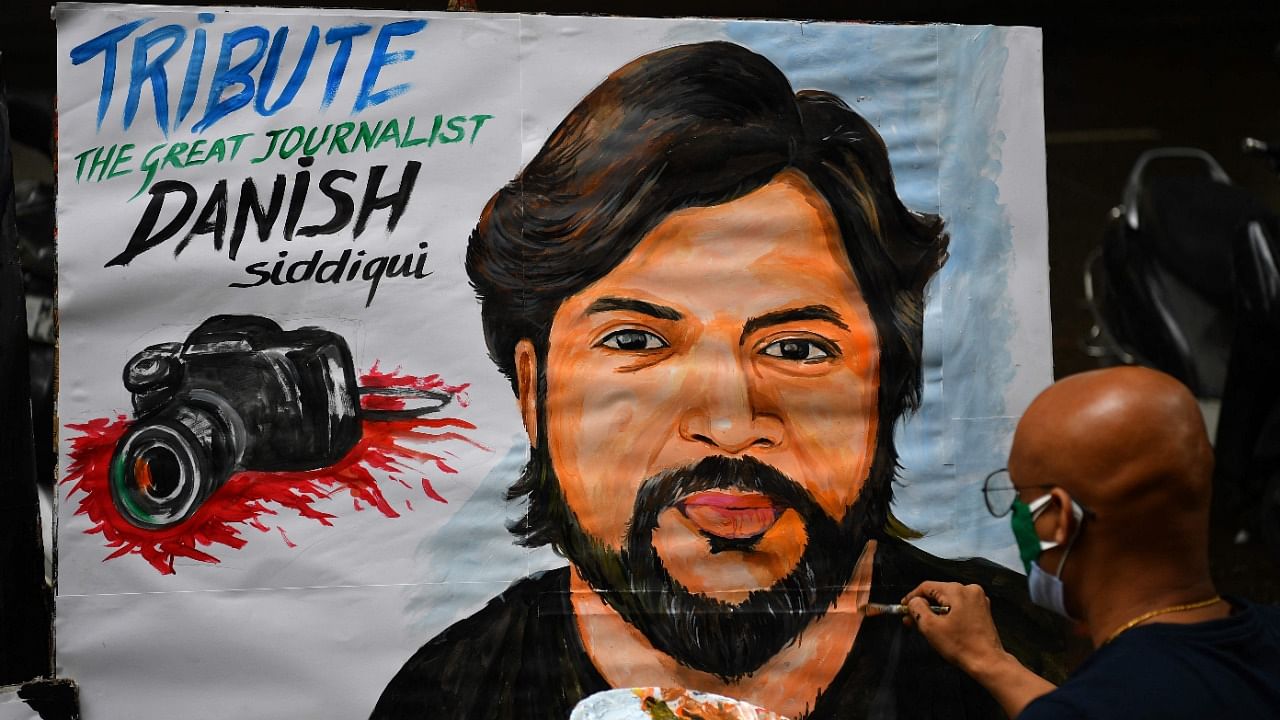 An art teacher gives finishing touches to a painting of Reuters journalist Danish Siddiqui as a tribute outside an art school in Mumbai. Credit: AFP Photo