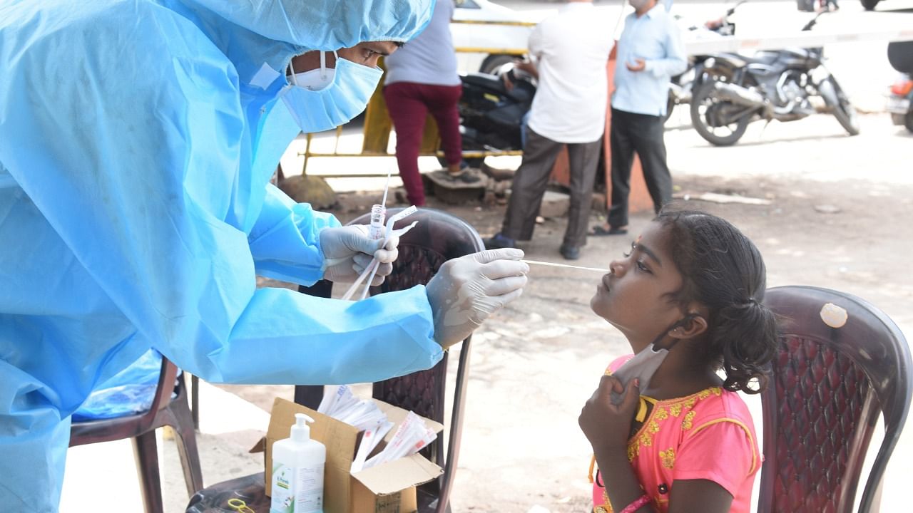A health worker collects a child's nasal swab. Credit: DH Photo/S K Dinesh